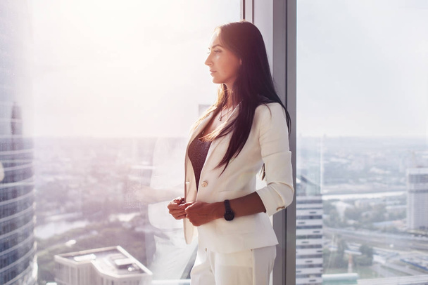Portrét šéfa zamyšlený úspěšná mladá žena stojící u okna v úřadu při pohledu na panorama - Fotografie, Obrázek