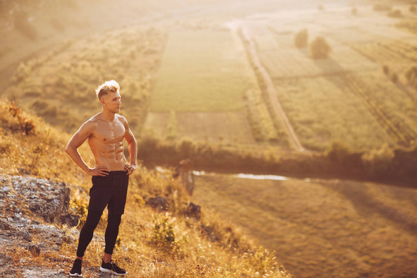 Handsome man standing on hill - Photo, Image