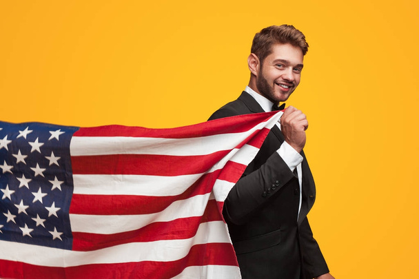 Man in suit holding USA flag - Foto, immagini