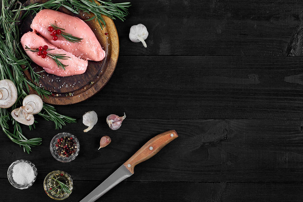 Syrové kuřecí prsa filety na dřevěném prkénku s bylin, koření a houby. Pohled shora s kopií prostor - Fotografie, Obrázek