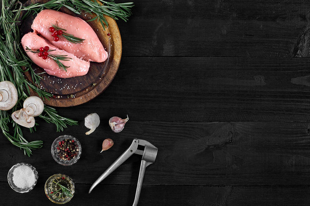 Syrové kuřecí prsa filety na dřevěném prkénku s bylin, koření a houby. Pohled shora s kopií prostor - Fotografie, Obrázek