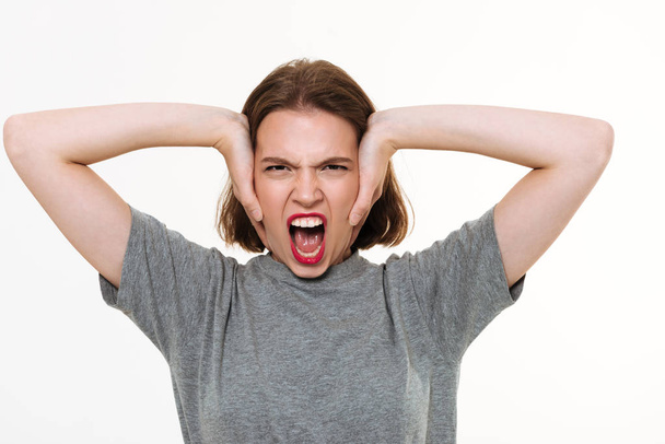 Angry screaming young caucasian lady standing isolated - Фото, изображение