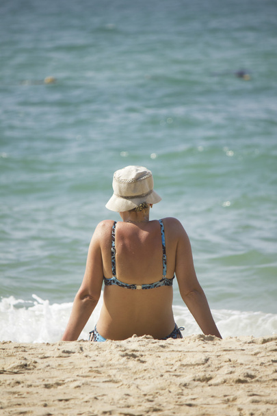 Donna seduta sulla spiaggia e a guardare il mare
 - Foto, immagini