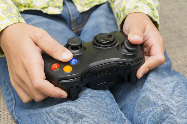 Hände, die einen Joystick-Controller halten, während sie ein Videospiel spielen - Foto, Bild