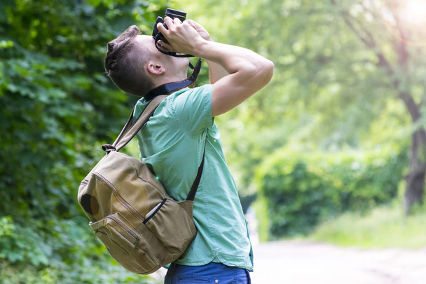 A young man takes photos of nature in the woods - Fotó, kép