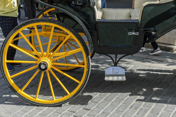 Detalle de la rueda amarilla del carro de caballos en Sevilla España
 - Foto, imagen