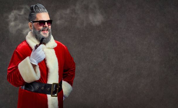 Santa Claus with a hairstyle and a cigar launches a smoke. - Photo, Image