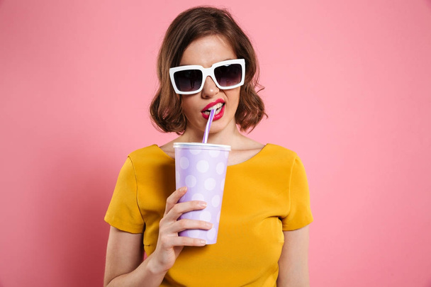 Portrait of a girl in sunglasses holding cup with drink - Fotoğraf, Görsel