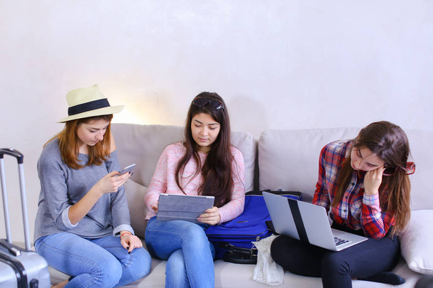 Τρεις αδελφές νεαρές γυναίκες χρησιμοποιούν gadgets και επικοινωνούν με κάθε - Φωτογραφία, εικόνα