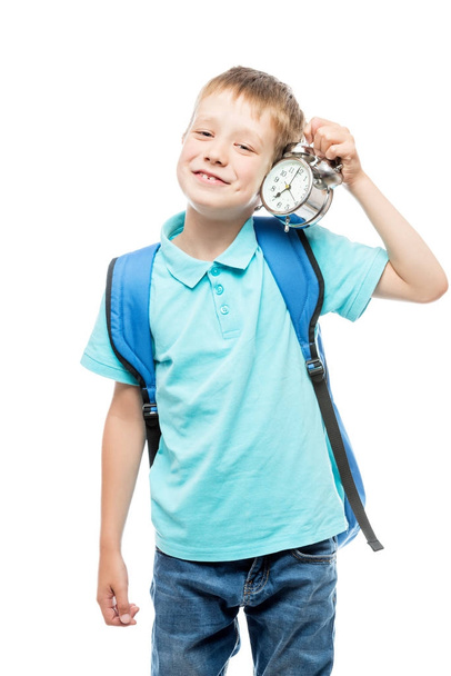 schoolboy with an alarm clock in the morning on a white backgrou - Foto, Imagen
