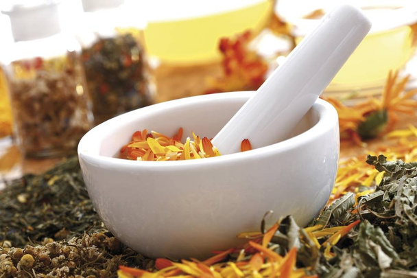 Homeopathic medicinal plant, mortar and pestle with pot marigold petals - Foto, afbeelding