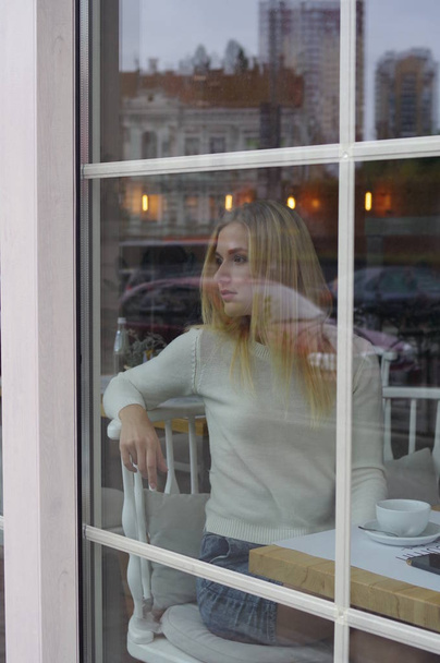 Girl is waiting for someone in a cafe. - Zdjęcie, obraz
