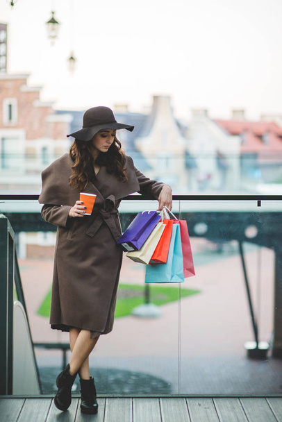 ショッピング バッグやコーヒーを持つ若い女性 - 写真・画像