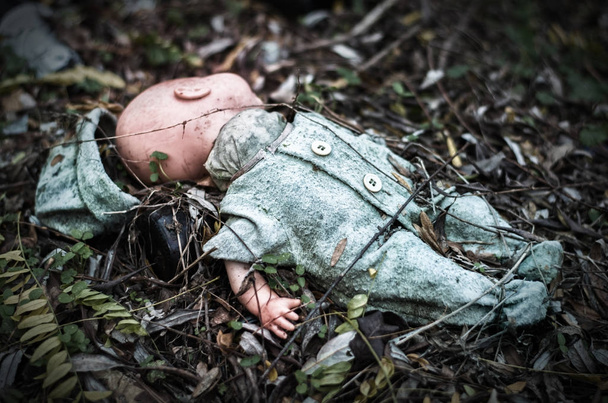 abandoned old broken baby doll rots in scary forest - Valokuva, kuva