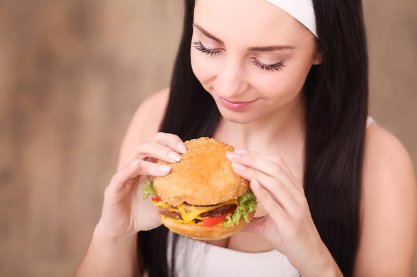 Mujer joven comiendo comida rápida
 - Foto, imagen