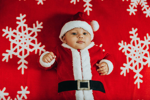 Різдво портрет чарівні новонародженого дитини носити костюм Санта-Клауса, лежачи на Сніжинка ковдру, вид зверху. - Фото, зображення