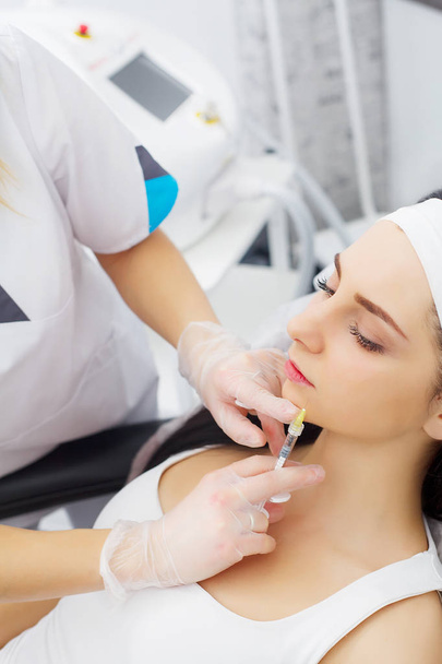 Vrouw ontvangen een injectie van botox in de zone van de lippen liggen in Bad - Foto, afbeelding