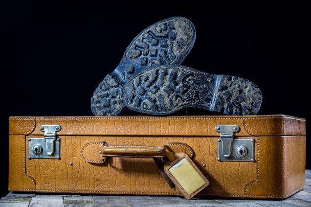 Old stylish suitcase. Military muddy shoes on a suitcase. Suitca - Photo, Image