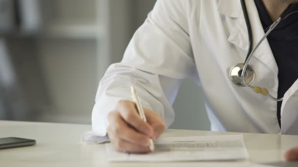 Experienced physician completing health insurance claim form, healthcare - Záběry, video