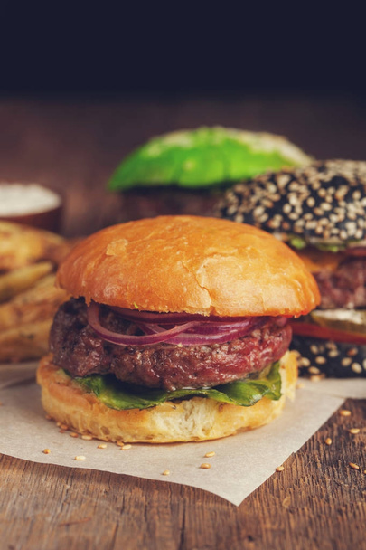 Closeup of set of three mini homemade Burger with marble beef and vegetables on a wooden Board - Photo, Image