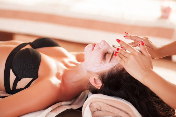 Спа-масаж. Красива жінка отримує спа-масаж на сонячному пляжі в спа
 - Фото, зображення