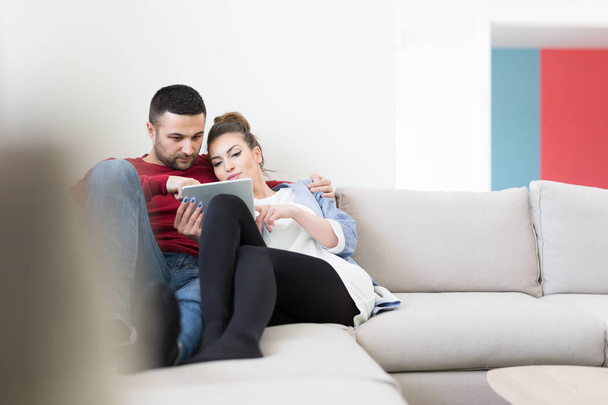 pareja relajante en casa usando tableta
 - Foto, Imagen