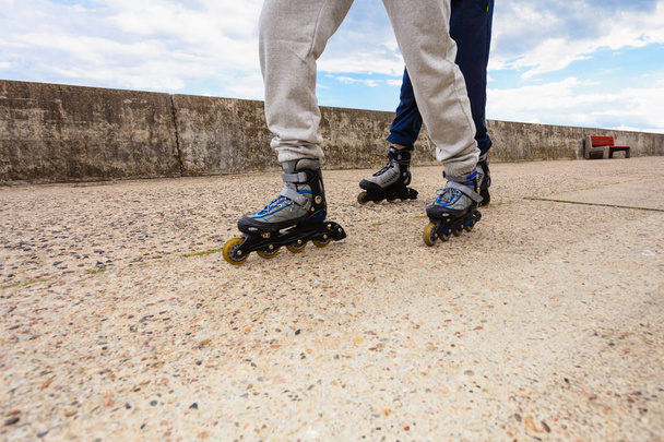 Two people race together riding rollerblades. - Foto, afbeelding