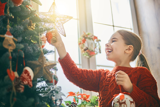 girl is decorating Christmas tree - Zdjęcie, obraz