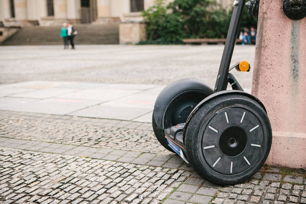 Gyroskop je zaparkováno na zdi na náměstí v Berlíně. Moderní individuální transport. - Fotografie, Obrázek