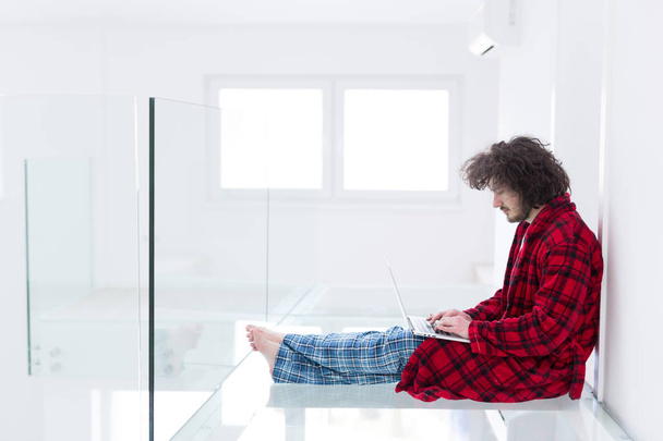 Freelancer in bathrobe working from home - 写真・画像