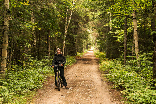 Girl with bicycle biking Canada Ontario Lake of two rivers natural wild landscape in Algonquin National Park - Foto, Imagen