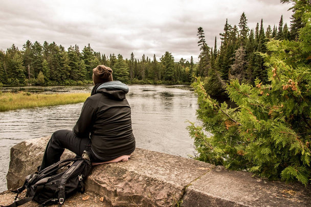 Girl sitting near Lake of two rivers in Algonquin National Park Canada Ontario natural pinetree landscape - Foto, imagen