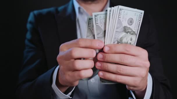 Un homme en veste noire et chemise blanche tenant de l'argent
 - Séquence, vidéo