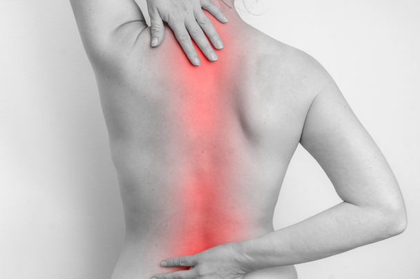 Mujer con dolor en la columna vertebral está sosteniendo su dolor de espalda
 - Foto, imagen