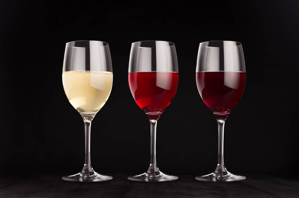Wine glasses set with red, rose, white wine,  mock up on elegant dark black wooden background. - Fotoğraf, Görsel