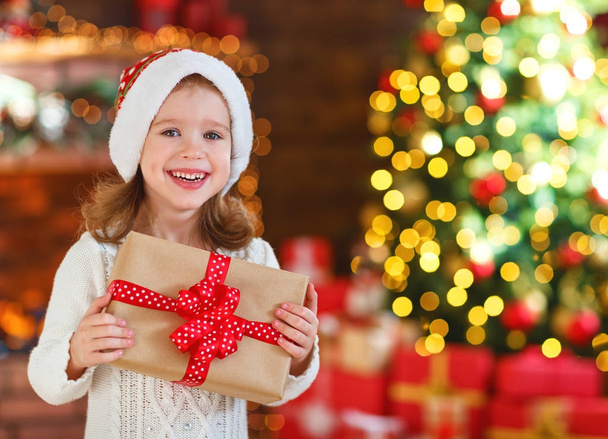 happy laughing child girl with christmas present at home - 写真・画像