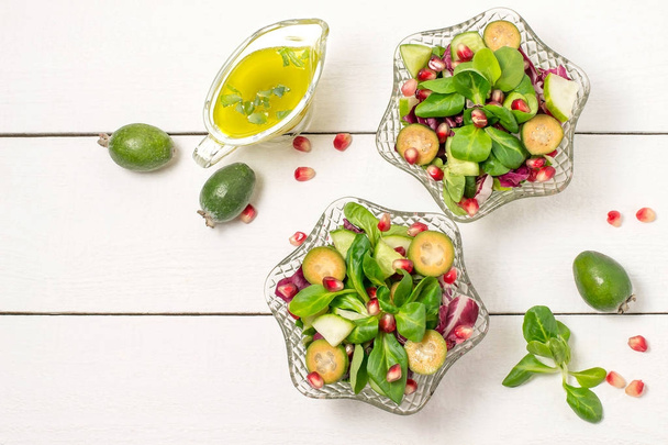 Свежий салат с огурцами, фейхоа, гранатом и листьями салата
 - Фото, изображение