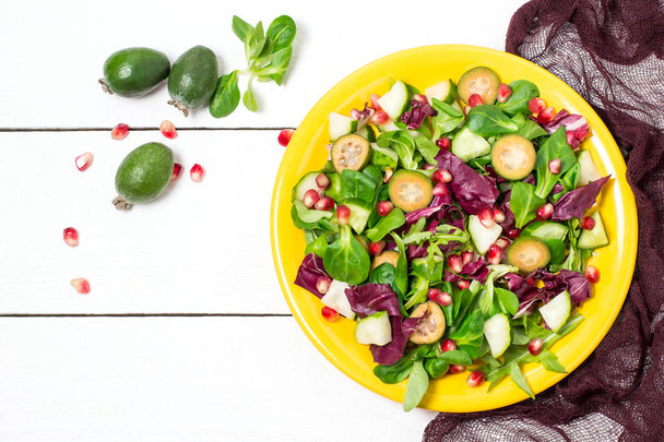 Ensalada fresca con pepinos, feijoa, granada y hojas de ensalada
 - Foto, imagen