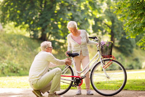 onnellinen vanhempi pari polkupyörällä kesäpuistossa
 - Valokuva, kuva