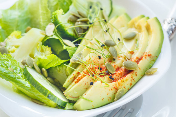 Green salad with broccoli, sprouts and avocado, light background - Foto, immagini
