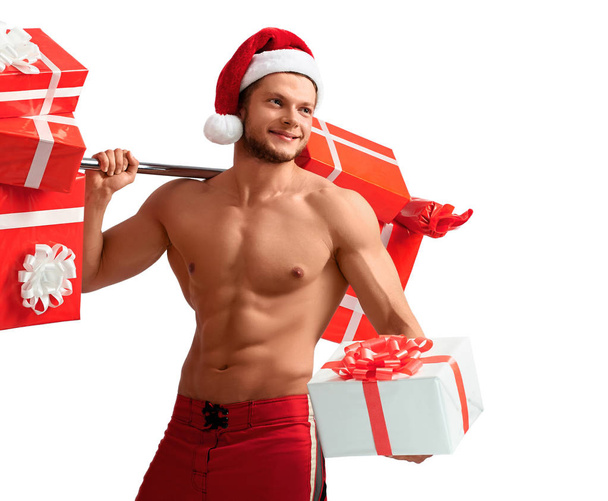 Ripped Santa Claus holding barbell and giving presents - Foto, afbeelding