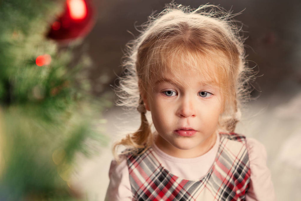 Niño bonito cerca del árbol de Navidad
. - Foto, imagen