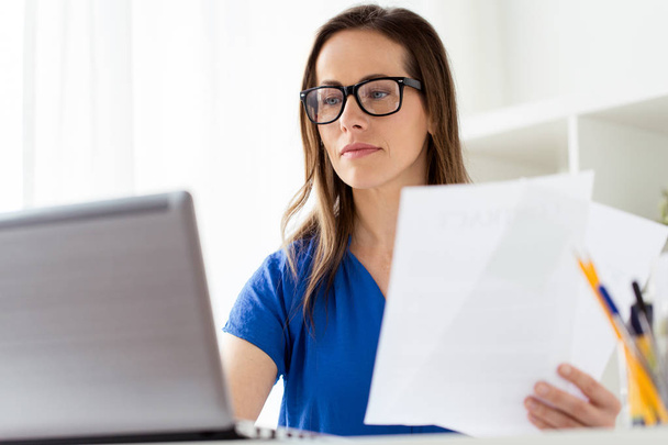 businesswoman with papers and laptop at office - Photo, Image