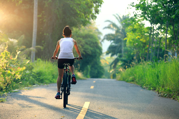 woman cycling on forest trail - Valokuva, kuva
