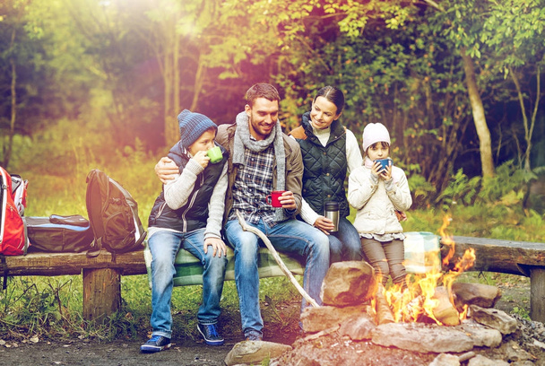 happy family sitting on bench at camp fire - Foto, Imagem