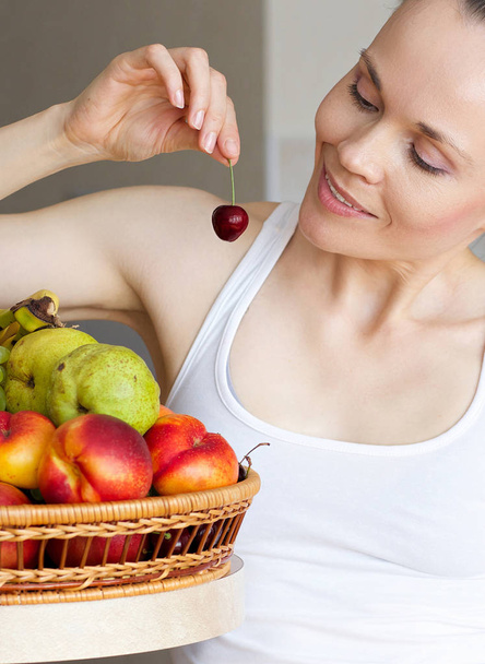 Mujer joven está comiendo frutas
 - Foto, imagen