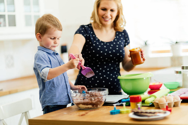  child helping mother in kitchen - Zdjęcie, obraz