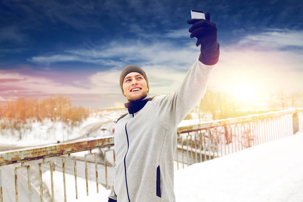 man taking selfie with smartphone in winter - Foto, imagen