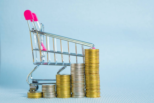 Step of stacks of coins and shopping cart or supermarket trolley - Photo, image