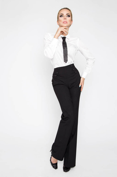 schöne, elegante, sexy blonde Model in weißen Hemden und Krawatte und schwarzer Hose gekleidet. sinnliche Geschäftsfrau mit Brille - Foto, Bild